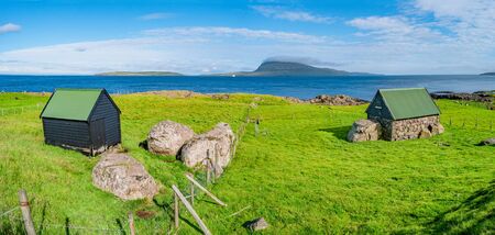 Panoramic view of Faroe islands seashore with traditional farm houses, summer timeの写真素材