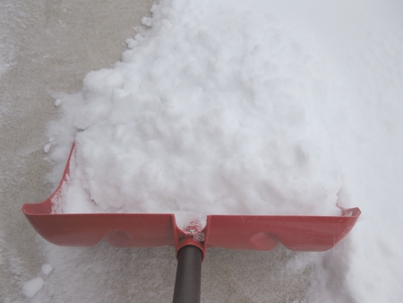 Snow shovel shoveling snow close-upの写真素材