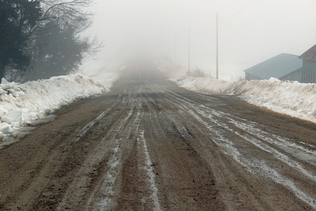 Beat up gravel road in winterの写真素材
