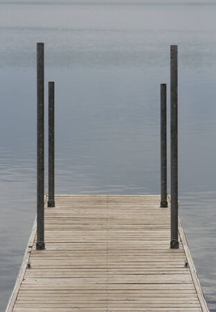 Wooden dock with blue waterの写真素材