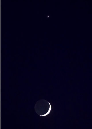 Planet Jupiter directly above a crescent moon at twilightの写真素材