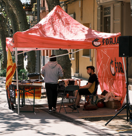 Two men talk. They sell t-shirts and books on the street.のeditorial素材