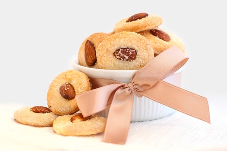 Cookies with almond in the center, dish decorated with ribbon and laceの写真素材
