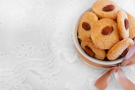 Cookies with almond in the center, dish decorated with ribbon and laceの写真素材