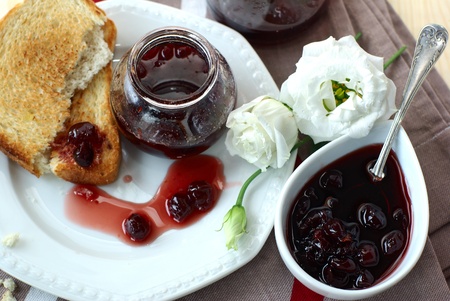 Sweet cherry jam, toast and white flowersの写真素材