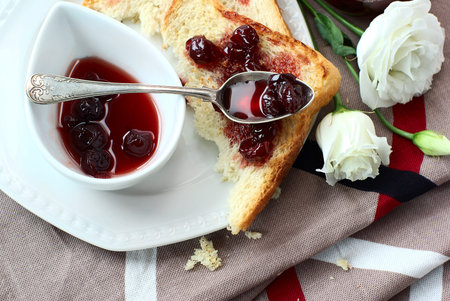 Sweet cherry jam, toast and white flowersの写真素材