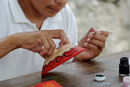 Mexican traditional ceramics painter. Close-up hands with brushの写真素材