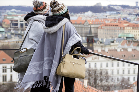 Two young unrecognizable women look at the Prague city from above.の写真素材