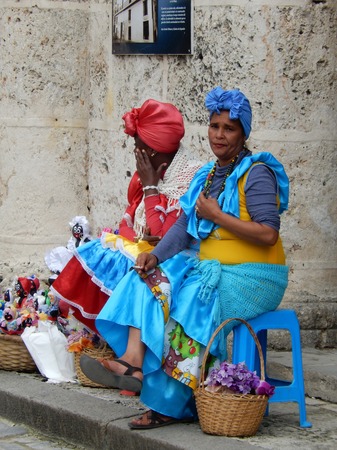 Havana, Cuba - January 19, 2016: Two cuban ladies dressed in traditional colorful dresses in a street of Old Havana, Cuba.のeditorial素材