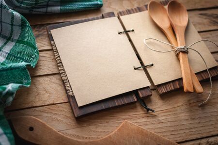 Blank vintage recipe cookbook and utensils on wooden background, copy spaceの写真素材