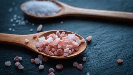 Close-up of Himalayan pink salt in wooden spoon, on dark backgroundの写真素材
