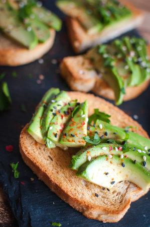 Close-up of fresh avocado toast with spices on dark background