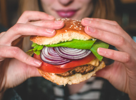 Close-up of smiling girl holding a homemade burgerの写真素材