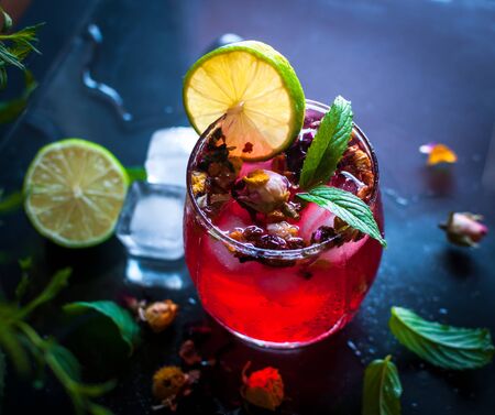 Close-up of homemade flower ice tea in a glass with fresh mint, on dark backgroundの写真素材