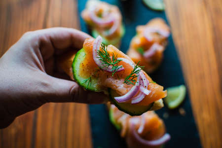 Close-up of smoked salmon on a baguette with cream cheese, cucumber, pickled red onion and fresh dill, top viewの写真素材