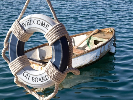 old wooden boat on the sea and safe belt with sign welcome on boardの写真素材