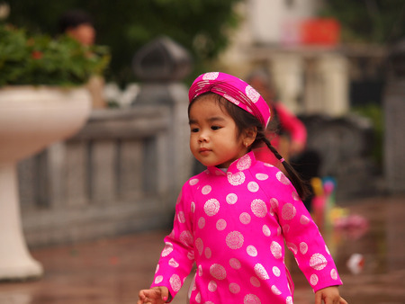 HO CHI MINH CITY, VIET NAM- FEB16:,Portrait of a handsome Asian  girl on traditional festival costume. Cute little Vietnamese girl  in ao dai dress smiling. Tet holiday. Lunar New Year Vietnam, Feb 16, 2015のeditorial素材