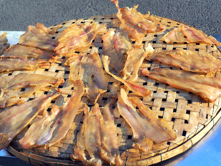 Dried fish on the bamboo grid in the sunny day , Dried fish dry in sunlight. Dried fish is dry foodstuff, this food product by mix salt with fresh fish and then place them under sunlightの写真素材