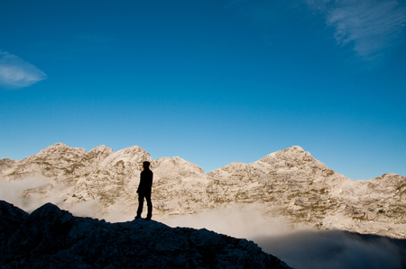 Silhouette of hiker in scenic landscape in mountains of Julian Alps, Sloveniaの写真素材