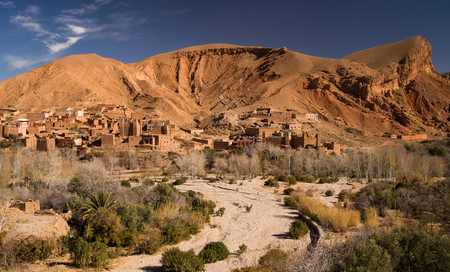 Old traditional desert kasbah village in Moroccan rock desertの写真素材
