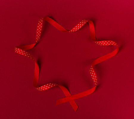 Wavy polka dot red ribbon on red background.の写真素材