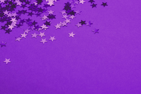 Beautiful festive ultra violet background with metallic star shaped confetti. Holiday or decoration concept.の写真素材