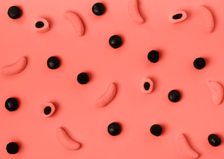 Stylish colorful candy pattern on pastel background. Top view. Flat lay. Backdrop for your design. Color of the year 2019. Living coral.の写真素材