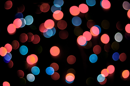 Abstract living coral and blue bokeh texture on black background. Defocused sparkles. Color of the year.の写真素材