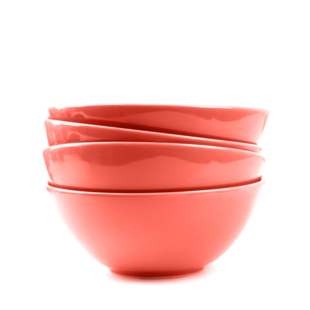 Stack of four ceramic bowls coral color isolated on white. Color trend of the year.の写真素材