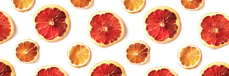 Pattern of dried slices of citrus on white background. Abstract food backdrop. Top view, flat lay style. Banner for website.の写真素材