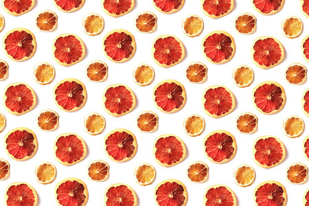 Pattern of dried slices of citrus on white background. Abstract food backdrop. Top view, flat lay...