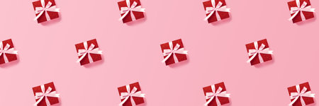 Festive pattern of red gift boxes with pink ribbon on pink background. Christmas, Valentines day or birthday concept. Minimal festive concept. Banner for website.の写真素材