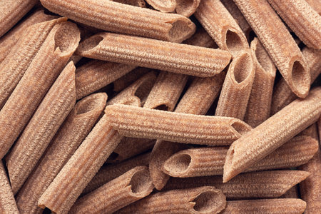 Dry buckwheat penne pasta backround. Closeup view.の写真素材