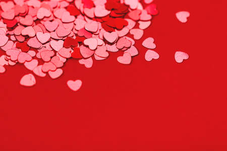Beautiful festive background with red metallic heart shaped confetti. Valentines day background. Copy space for your text. Selective focus.の写真素材