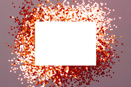 Mockup of greeting card on festive background with sparkling confetti. Holiday or Invitation concept. Place for text. Flat lay, view from above.の写真素材