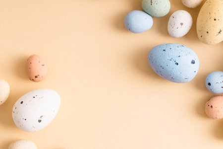 Multicolor mini Easter candy eggs on beige background. Holiday decoration concept. Place for text.