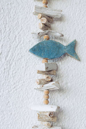 Woden decoration hanging on a white wall. Sea decoration concept.の写真素材