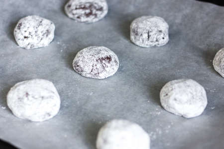 Cookie dough rolled in balls on a parchment paper.の写真素材
