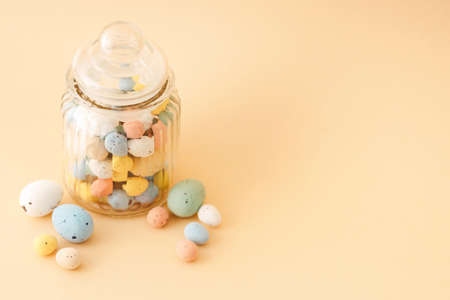 Multicolor Easter candy eggs on beige background.の写真素材