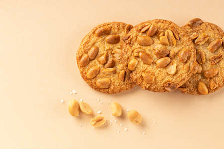 Cookies with roasted peanuts on top on beige background.の写真素材
