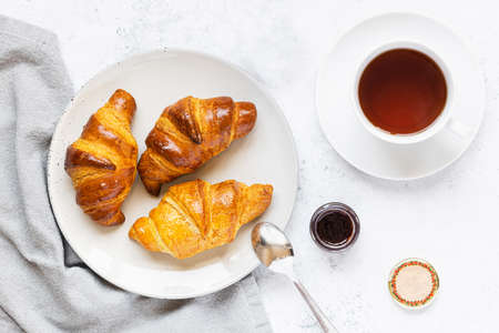 Breakfast scene. Croissants on plate and cup of tea.の写真素材