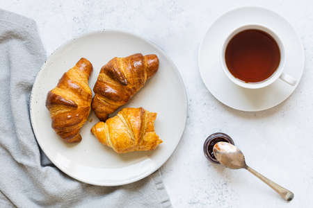 Breakfast scene. Croissants on plate and cup of tea.の写真素材