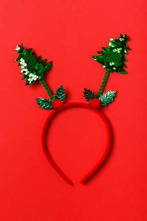 Funny christmas tree headband on red background. Festive minimal Christmas concept.の写真素材