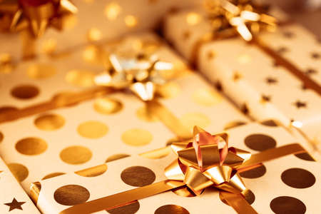 Wrapped Christmas gift boxes with golden bows and ribbon.の写真素材