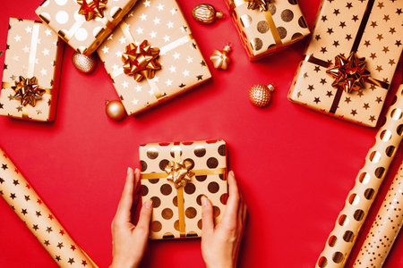 Gift boxes with golden bows and ribbons on red background.