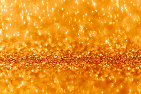 Festive abstract blurred glitter background golden color.