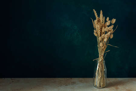 Minimalistic bouquet of beautiful dried flowers on dark background.の写真素材