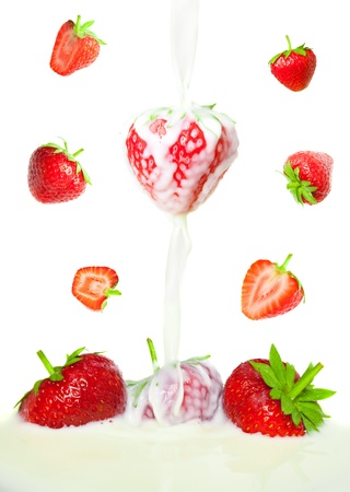 many beautiful strawberries falling in milkの写真素材