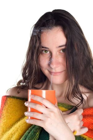 sleepy smiling girl rolled in a rug drinks hot teaの写真素材