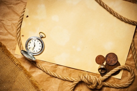 antique money with watch and rope on old yellow paperの写真素材